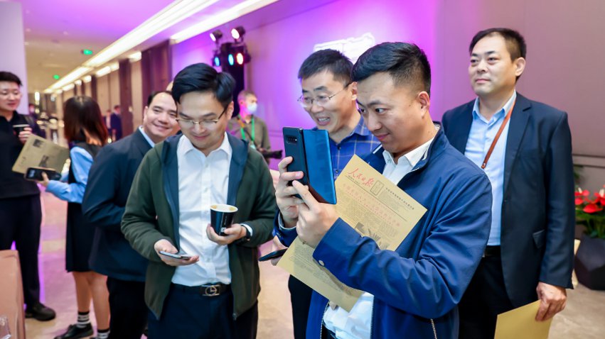 人民網(wǎng)研發(fā)推出的《人民日報(bào)》生日報(bào)吸引嘉賓體驗(yàn)。主辦方供圖